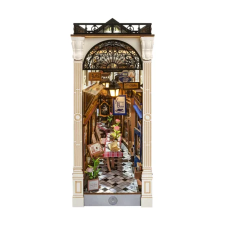 Narrow ornate storefront opening to a cozy Parisian-style cafe and bookstore with checkered floor and hanging signs.