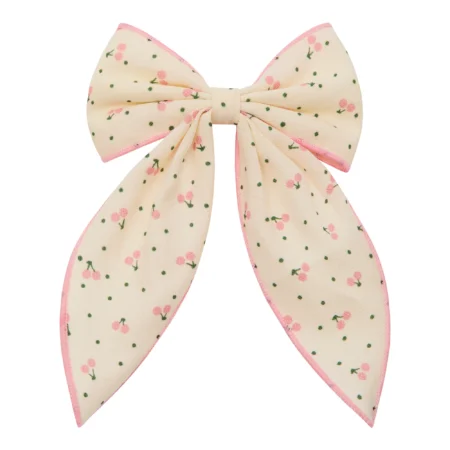 Cream hair bow with pink edges and tiny pink flowers on a pale background