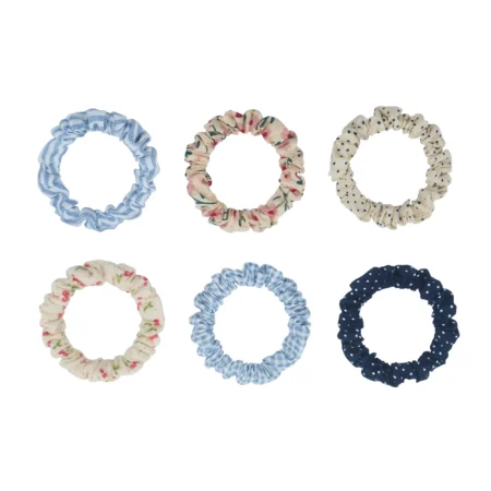 Six fabric scrunchies in two rows: light blue striped, pink floral, cream with dots, cream with pink flowers, solid light blue, and navy with white dots.