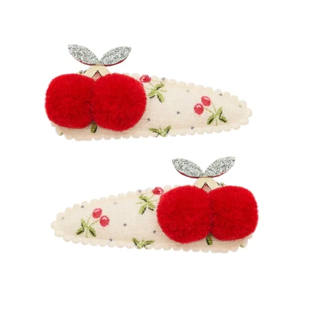 Pair of hair clips with red fuzzy cherry decorations on cream fabric featuring tiny cherry prints.