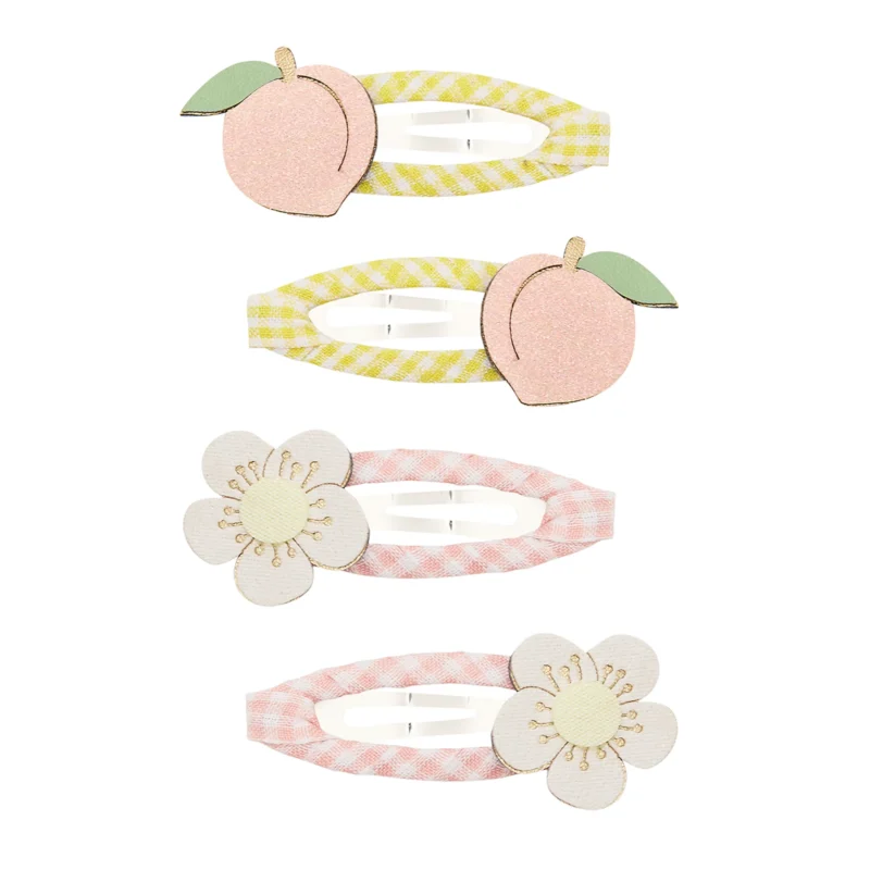 182098-23-peach-blossom-clic-clacs-_69932c29d04c8_2000x2000r Four pastel gingham hair clips: two peach-shaped embellishments and two flower-adorned clips on a white background.