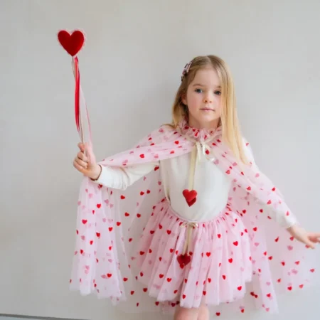 Girl in a pink heart-patterned tutu and cape, holding a heart-topped wand.