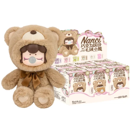 Brown plush bear toy with a girl doll wearing a bear hood and a brown ribbon, beside Nanci bear-themed packaging boxes.
