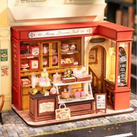Miniature bakery storefront labeled 'Honey Dessert Talk' with a display case of pastries and cupcakes outside on a cobblestone street.