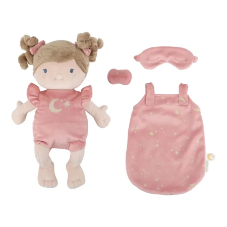 Soft pink plush girl doll with pigtail buns wearing a moon-and-stars dress, next to a matching pink sleep mask and small accessories.
