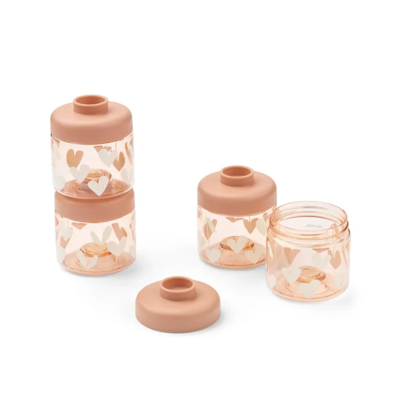 a29udGFpbmVyL25ldy80OTQ5LzE4MDM4MzcwdjEucG5n Set of peach-pink glass storage jars with white heart decorations and matching lids, one jar open.